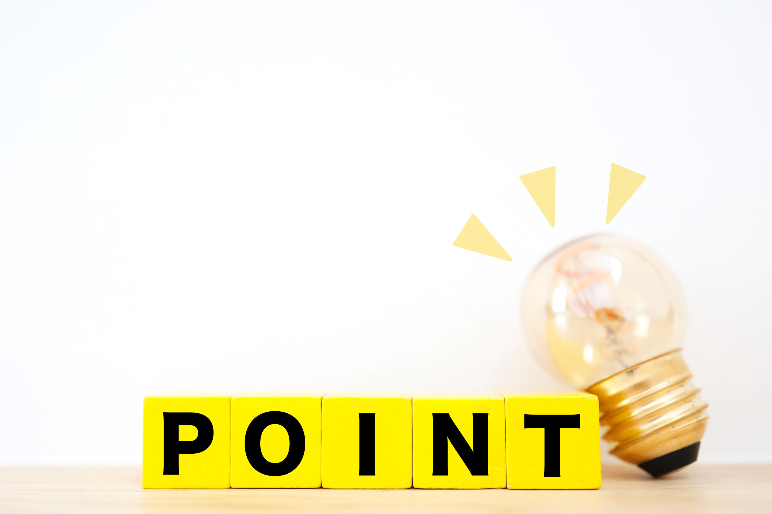 ポイントと輝く電球のイメージ素材。白背景にコピースペース。